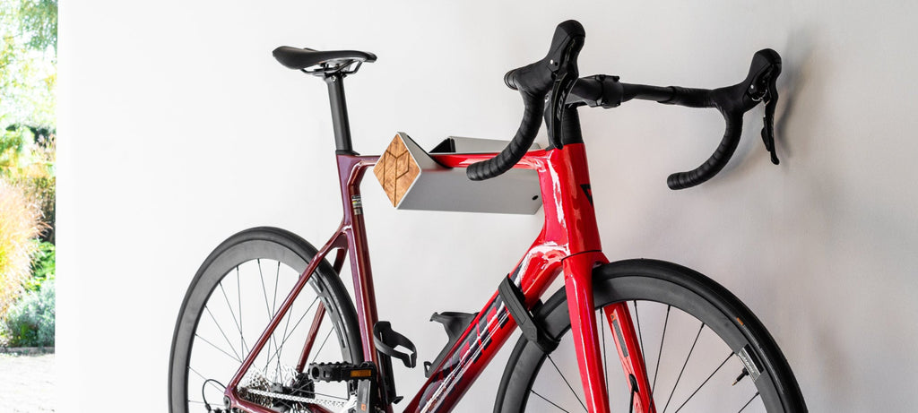 Rotes Fahrrad hängt auf silberner Fahrrad-Wandhalterung